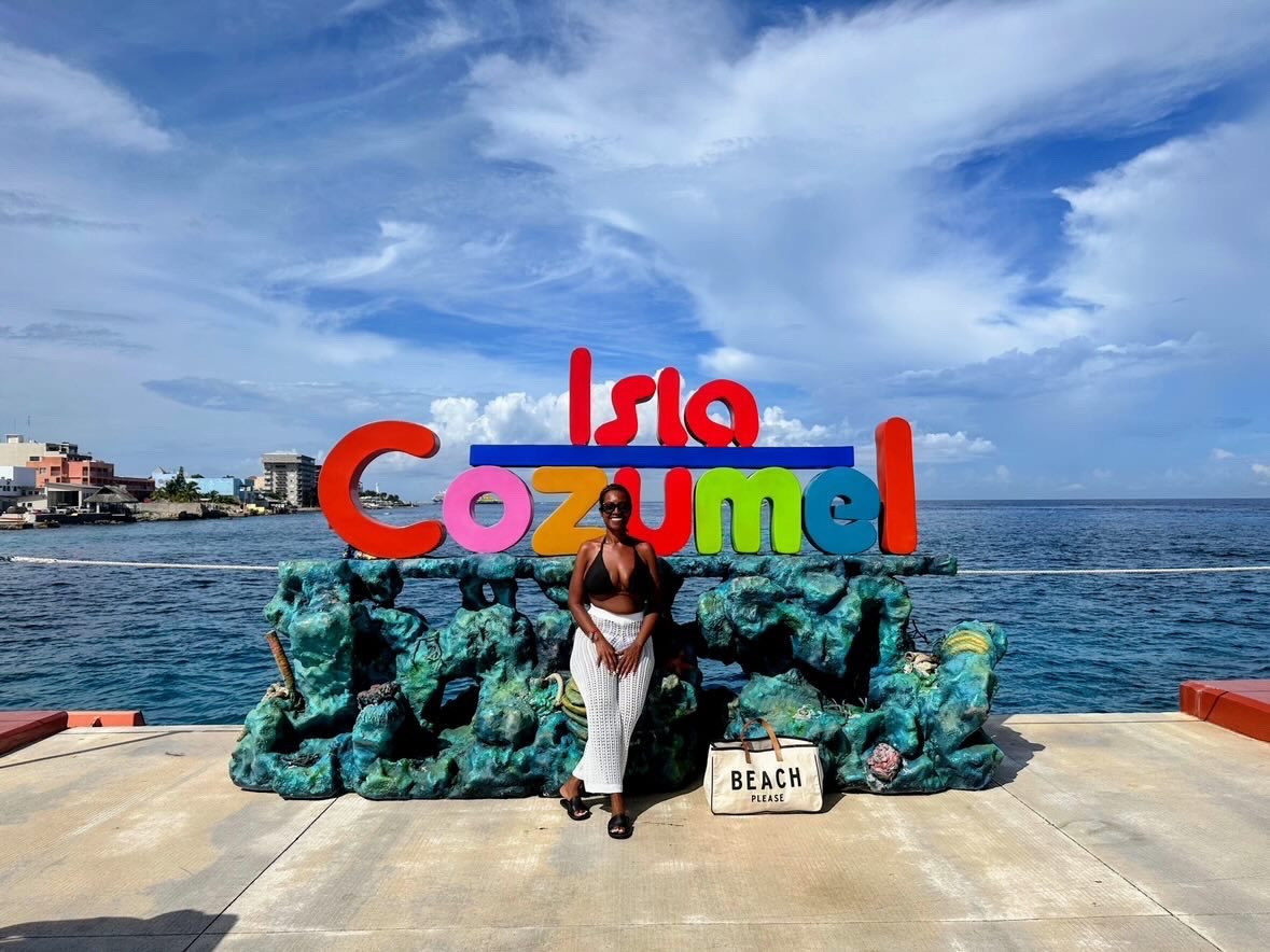 Arliee in front of the Isla Cozumel sign